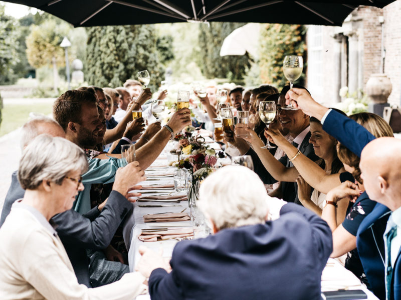 Gasten proosten op bruidspaar aan tafel